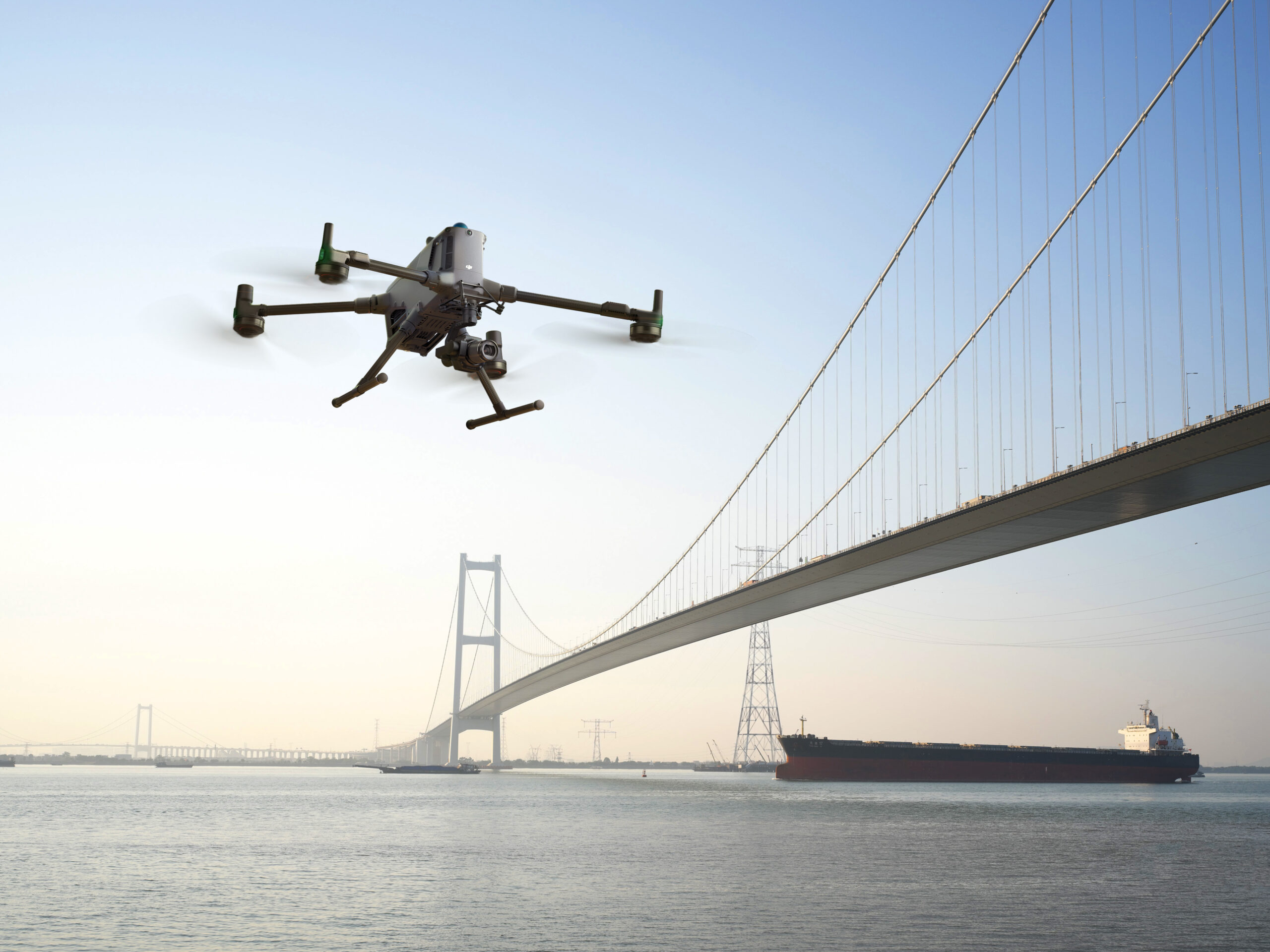 Drohne mit Zenmuse P1 Kamera fliegt über dem Wasser vor einer großen Hängebrücke