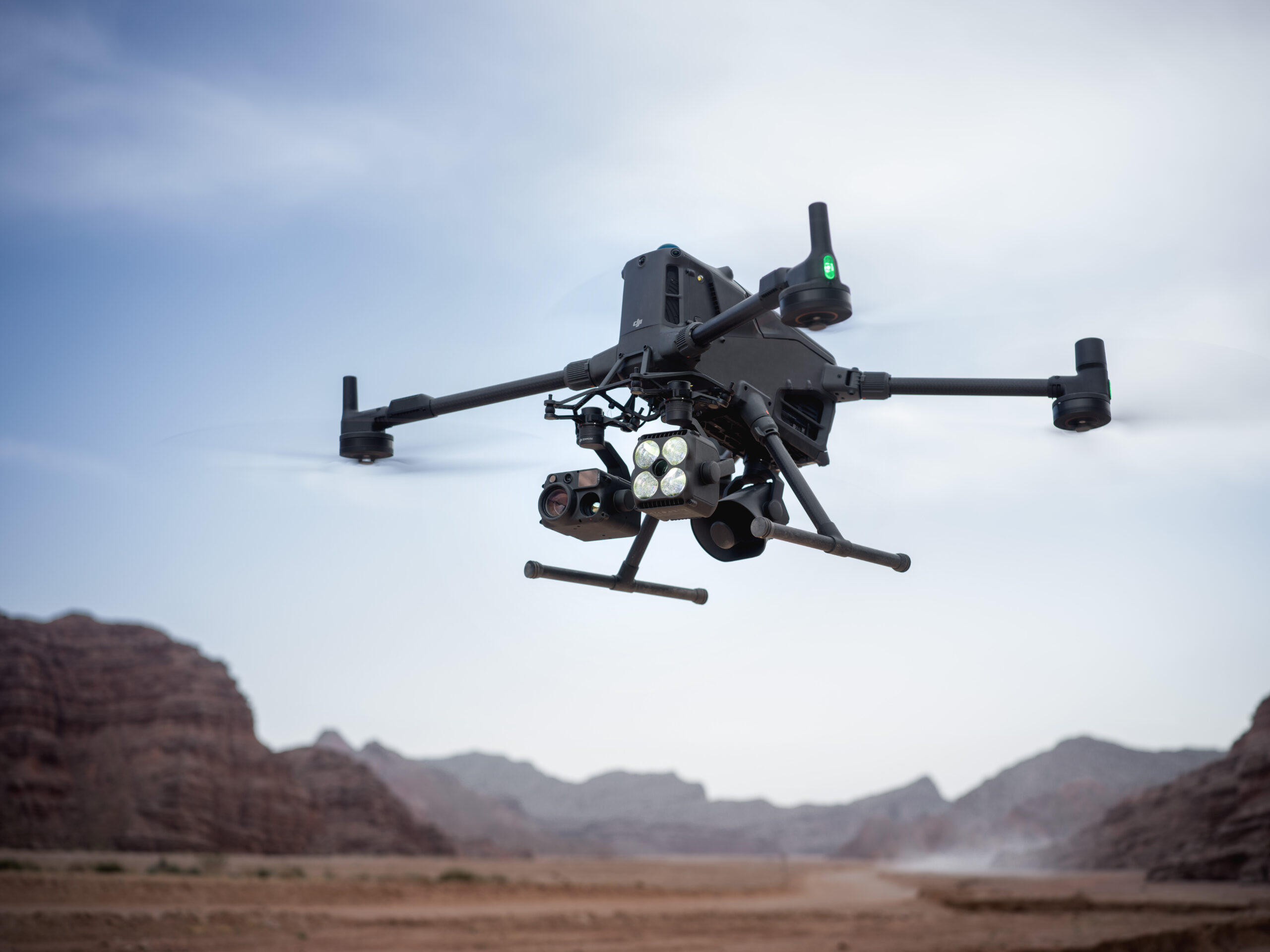 Industriedrohne mit Kamera und Scheinwerfer fliegt über einer Canyonlandschaft