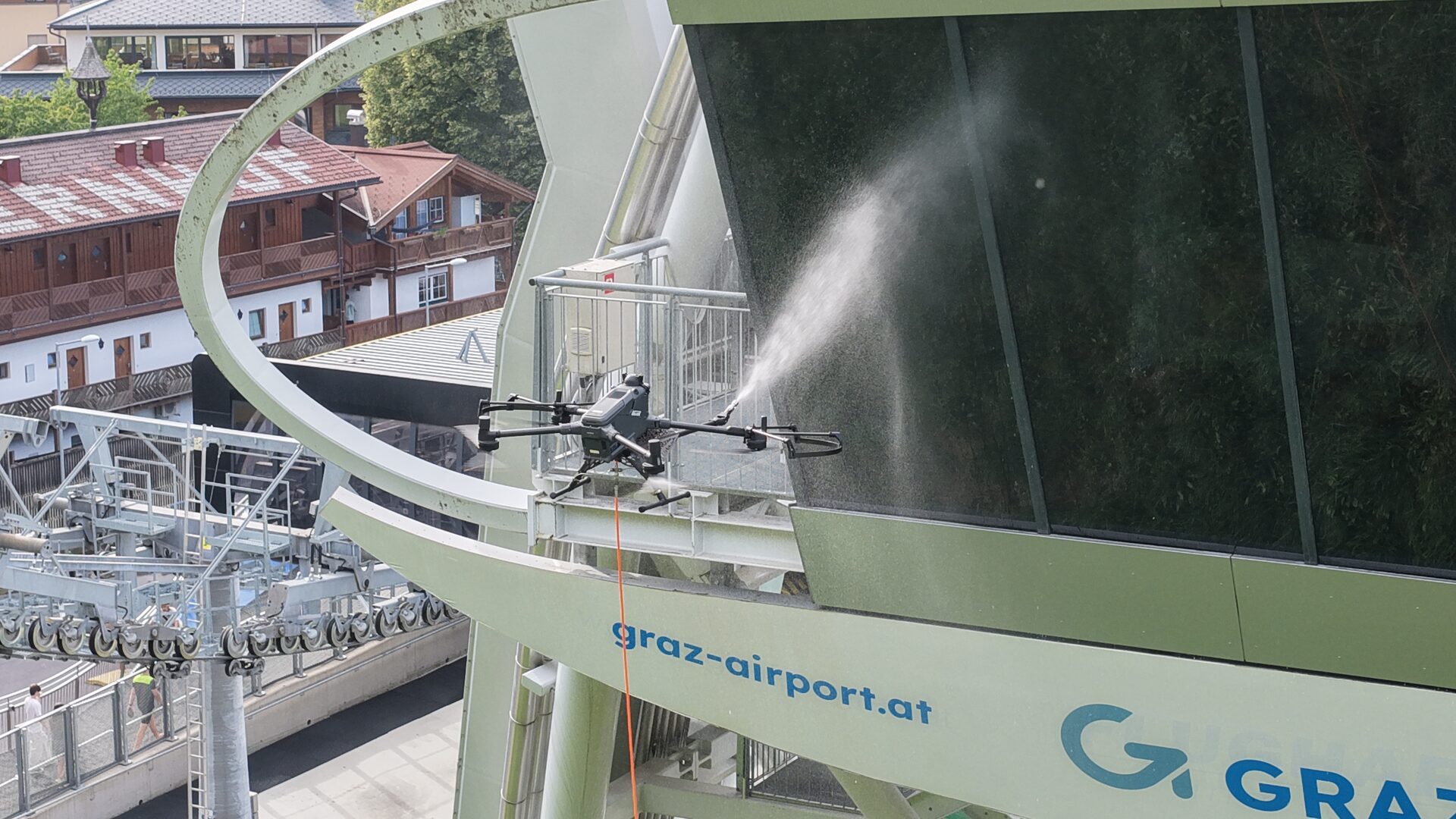 Reinigungsdrohne reinigt die Glasfront einer Seilbahnstation